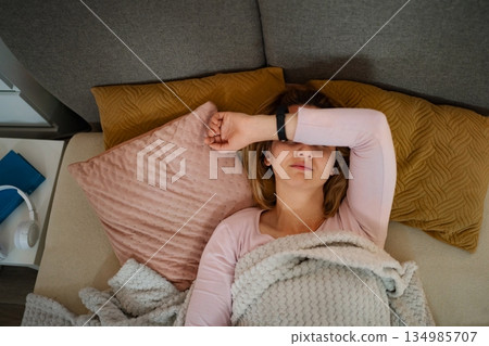 Tired woman resting on sofa experiencing headache 134985707
