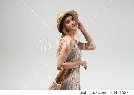 Young woman in straw hat adjusting hair while holding reusable mesh shopping bag with bread, eco friendly lifestyle portrait, sustainable grocery shopping Young woman in straw hat adjusting hair while holding reusable mesh shopping bag with bread, eco friendly lifestyle portrait, sustainable grocery shopping 134985821