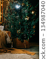 Decorated Christmas tree and cozy pallet sofa with a warm blanket, evoking a feeling of festive comfort. Holiday season interior decor for winter celebration. 134987040
