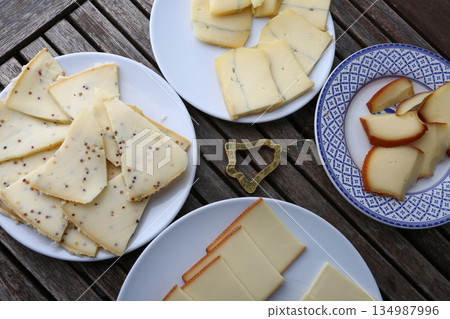 sliced cheese pieces for a traditional raclette lunch sliced cheese pieces for a traditional raclette lunch 134987996