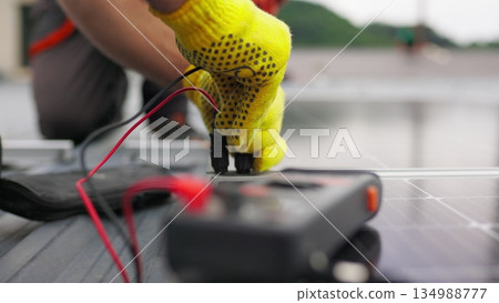 Close up, Solar energy specialist monitoring solar panels with his multimeter. Alternative, green energy worker. Energy engineer monitoring solar panels with his multimeter. Solar energy concept 134988777