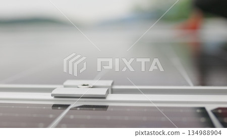 Close-up Installation, Connection and mounting of solar panels. Workers fasten solar panels. Technicians installing solar panels on metal stand. Workers installing solar panels on the roof of a house. 134988904