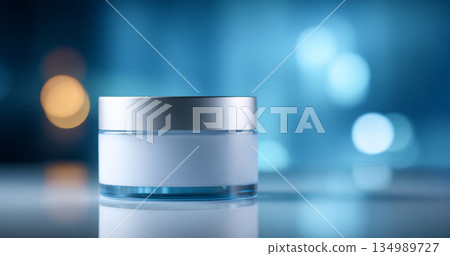 A white and blue cosmetic jar with a silver lid is on display against a blurred background of bokeh lights in shades of blue, yellow, and orange 134989727