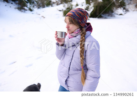 Snowy Winter Coffee Break: Girl In Purple Jacket Enjoys Hot Drink In Quiet Snowy Landscape 134990261
