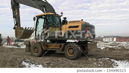 Bulldozer Rides on Sandy Road. Construction Machinery At Work On Building A House. Different Types Of Tractors And Excavators Prepare The Soil For Plant Construction In The Industrial Zone 134990323