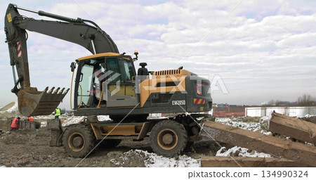 Bulldozer Rides on Sandy Road. Construction Machinery At Work On Building A House. Different Types Of Tractors And Excavators Prepare The Soil For Plant Construction In The Industrial Zone Bulldozer Rides on Sandy Road. Construction Machinery At Work On Building A House. Different Types Of Tractors And Excavators Prepare The Soil For Plant Construction In The Industrial Zone 134990324