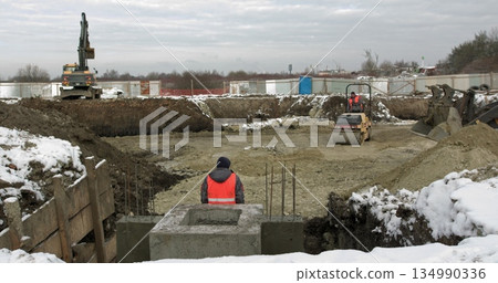 Loader excavator, bulldozer and roller work on construction site. Machines perform excavation work. Compaction of soil and rubble for residential buildings. Construction work. Loader excavator, bulldozer and roller work on construction site. Machines perform excavation work. Compaction of soil and rubble for residential buildings. Construction work. 134990336