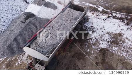 Aerial top view of a large truck unloading rubble on a construction site. Preparation for construction Aerial top view of a large truck unloading rubble on a construction site. Preparation for construction 134990359