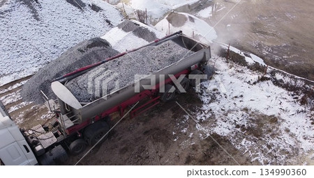 Aerial top view of a large truck unloading rubble on a construction site. Preparation for construction Aerial top view of a large truck unloading rubble on a construction site. Preparation for construction 134990360