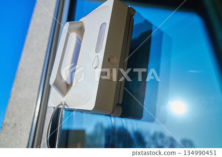 Window cleaning robot on glass surface Window cleaning robot on glass surface 134990451
