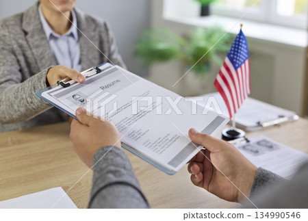 US visa and citizenship interview with officer reviewing applicant documents 134990546
