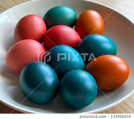 Colored Easter eggs arranged on plate in daylight. Holiday tradition, seasonal celebration, family ritual and decorative food styling Colored Easter eggs arranged on plate in daylight. Holiday tradition, seasonal celebration, family ritual and decorative food styling 134990839