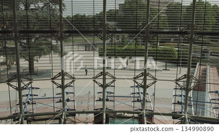 Handsomely dressed man goes to work in a large glass office. Businessman ode returns to the office. sunny day success slow motion. 134990890