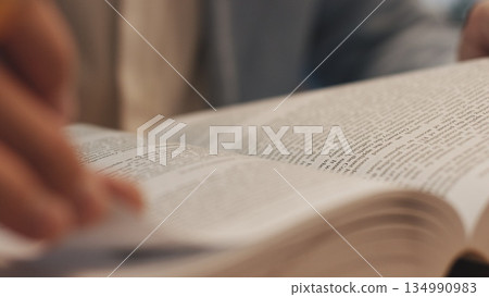 Unrecognizable lawyer's hand works with papers and law books in courtroom or office. Concept of justice and law, attorney or court judge. 134990983