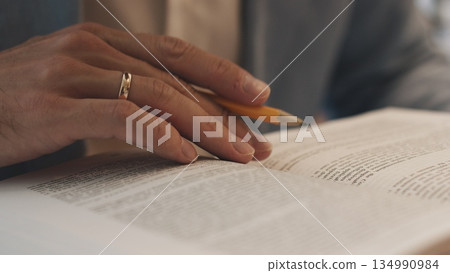Unrecognizable lawyer's hand works with papers and law books in courtroom or office. Concept of justice and law, attorney or court judge. 134990984