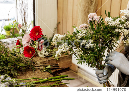 Florist arranging white flowers for bouquet creation, Mothers day 134991078