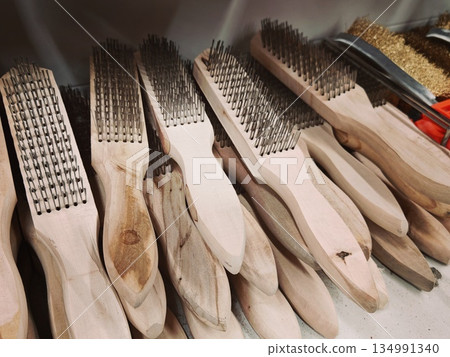 Wire Brushes Assortment Display. Multiple wooden-handled wire brushes arranged in pile for cleaning rust or heavy dirt in hardware store setting. 134991340