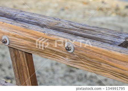 Metal supports Bolts, nuts, threaded on beams of the wooden fence. Metal supports Bolts, nuts, threaded on beams of the wooden fence. 134991795