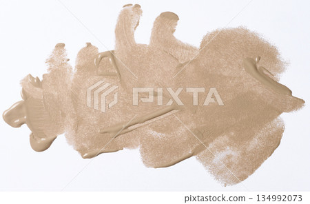 A broad brushstroke of nude or beige foundation with a distinct wave texture from the brush, glossy finish 134992073