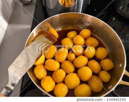 Brown caramelized potatoes frying in pan for Christmas Denmark Brown caramelized potatoes frying in pan for Christmas Denmark 134992295