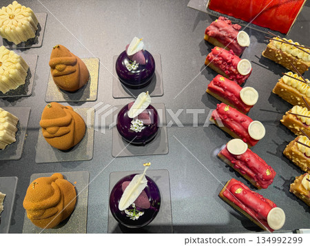 Assorted pastries and eclairs with chocolate glaze in cafe. Assorted pastries and eclairs with chocolate glaze in cafe. 134992299