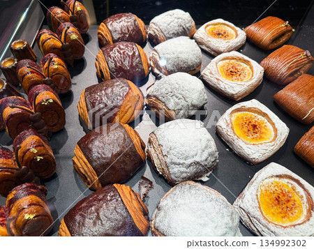 Fresh puff pastries with cream and chocolate in cafe. Fresh puff pastries with cream and chocolate in cafe. 134992302