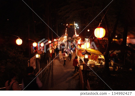 沿著通往神社的道路,可以看到一排排的食物攤位和燈籠。 沿著通往神社的道路,可以看到一排排的食物攤位和燈籠。 134992427