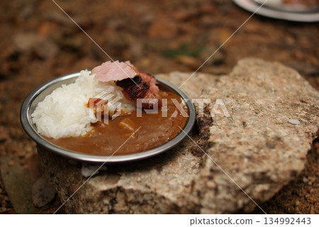 Curry rice and fragrantly grilled bacon served on a stone 134992443