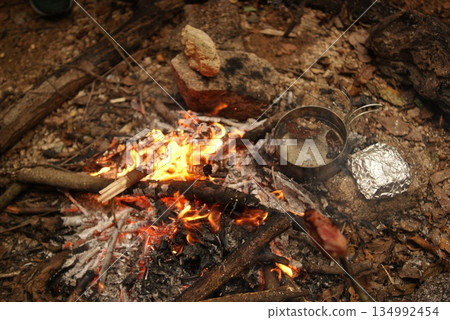 Camping meals cooked in a pot over an open fire and in foil 134992454