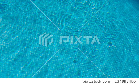 Turquoise swimming pool water with square tiles background Turquoise swimming pool water with square tiles background 134992490