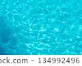 Bright blue water ripples at a swimming pool, summer background 134992496