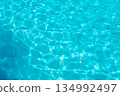 Turquoise water glistens in a sunny swimming pool, summer background 134992497