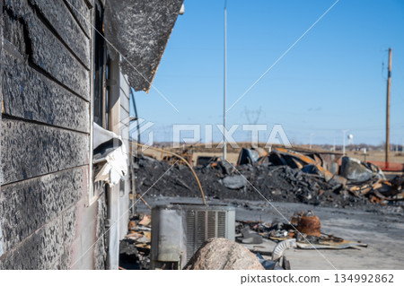 Destruction of a building after a fire in a rural area with debris scattered around 134992862