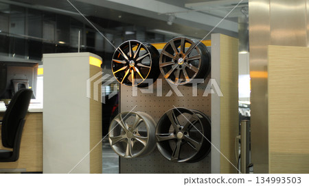 Aluminum alloy wheels on a wooden rack at car tuning showroom Aluminum alloy wheels on a wooden rack at car tuning showroom 134993503