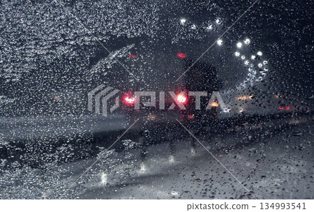 Look through ice and snow on frozen windshield on the snowfall on the night highway Look through ice and snow on frozen windshield on the snowfall on the night highway 134993541