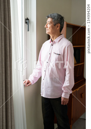 A man looking out the window A man looking out the window 134994204