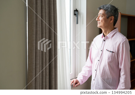 A man looking out the window A man looking out the window 134994205