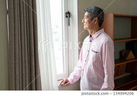 A man looking out the window A man looking out the window 134994206