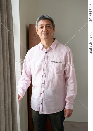 A man standing by the window A man standing by the window 134994209
