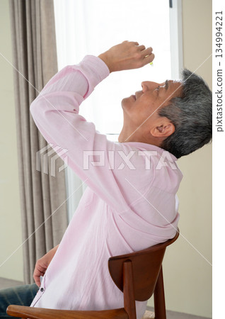 一名男子坐在椅子上滴眼藥水 134994221