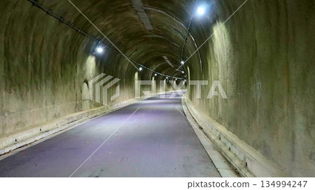 一條安靜的弧形隧道,燈光明亮。 一條安靜的弧形隧道,燈光明亮。 134994247