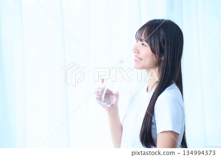 一位年輕女子凝視著水面，感受著水的濕潤。 134994373