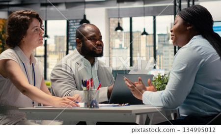 HR department team discussing with black woman about career opportunity, selecting candidates during job interview session in office. Applicant focused on strong career ambition. HR department team discussing with black woman about career opportunity, selecting candidates during job interview session in office. Applicant focused on strong career ambition. 134995012