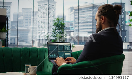 Visionary entrepreneur sits in a high end corporate workspace, focusing on investment planning and business development. Young CEO optimizing productivity to drive enterprise success. Camera A. 134995117