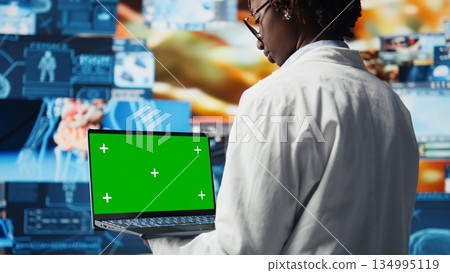 Isolated screen laptop used by healthcare researcher analyzing medical data visualizations, doing disease prevention. Chroma key notebook used by scientist doing patient scans research, camera A 134995119