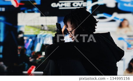 Person addicted to smartphone, looking at internet video channels, isolated over digital backdrop. African american woman enjoying metaverse video content on device, 360 degrees rotation, camera B Person addicted to smartphone, looking at internet video channels, isolated over digital backdrop. African american woman enjoying metaverse video content on device, 360 degrees rotation, camera B 134995156