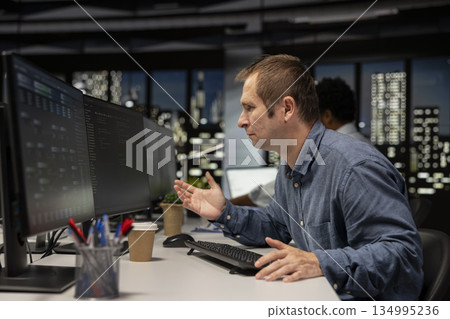 Irascible startup office admin frustrated by malfunctioning machine learning models enhancing automation. Tense Silicon Valley workplace IT employee irked by broken AI assistant on computer 134995236