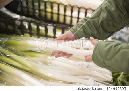 一位女顧客在一家超市撿長洋蔥 134996805