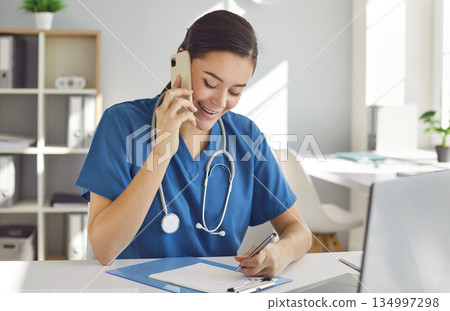 Nurse or doctor making phone calls, talking to patients, and scheduling appointments Nurse or doctor making phone calls, talking to patients, and scheduling appointments 134997298