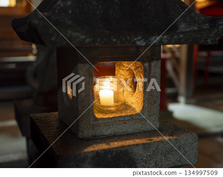 Stone lantern with a lit candle 134997509